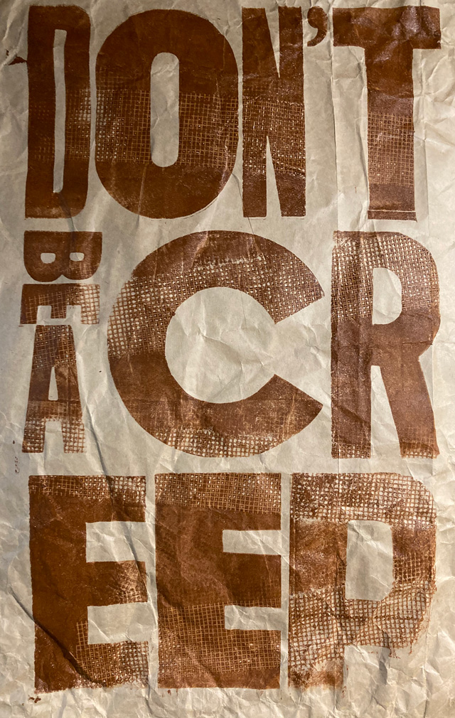 Don’ BE A CREEP letterpress print brown ink with some mesh texture on wrinkled paper from a recycled flour sack 