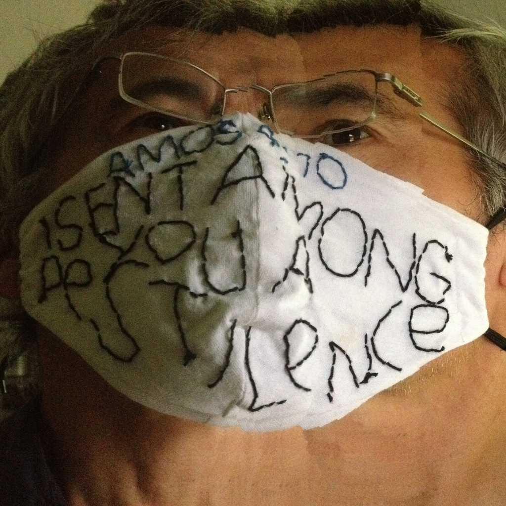 distorted image of my face wearing a homemade protctive mask crudely hand embroidered with a bible verse: Amos monoline grotesk style alphabet>
<p> Amos 4:10, I SENT AMONG YOU A PESTILENCE. An attempt to put an ironically humorous spin on the necessity of wearing a mask in everyday life and inspired bthe work of quilt artist Rosie Lee Tomkins.
