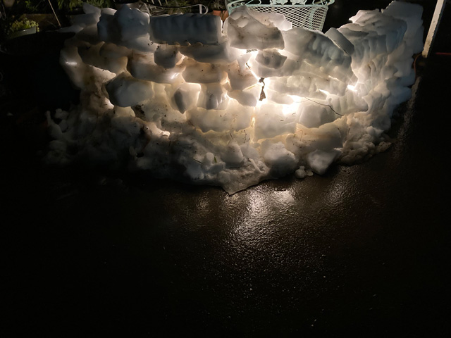 a backlit wall made of blocks of snow shot at night